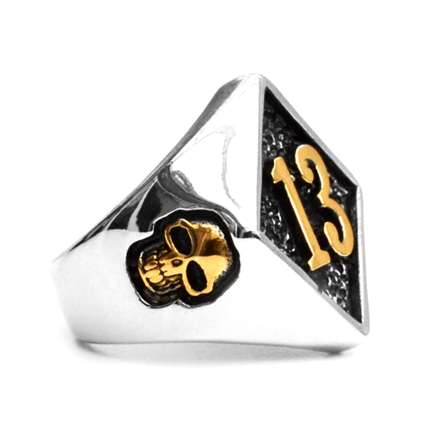 A silver and gold Lucky 13 Gold Skull Ring with the number 13 on it, from Rebel Saint Co.