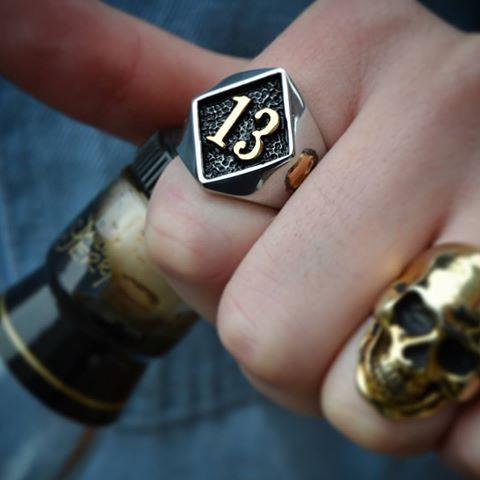 A silver and gold Lucky 13 Gold Skull Ring with the number 13 on it, from Rebel Saint Co.